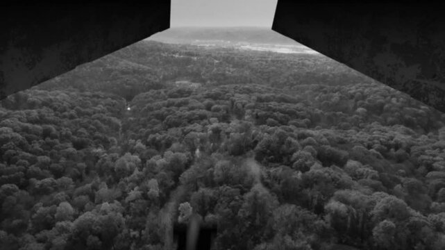 A grainy black and white film look view from inside a World War II plane carpet bombing the enemy landscape. Simulated.	