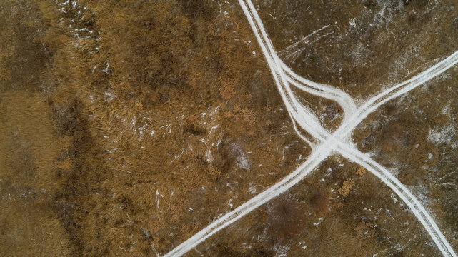 Close up of a dirt road with a white line down the middle. Frozen channels of the great Russian Volga River.