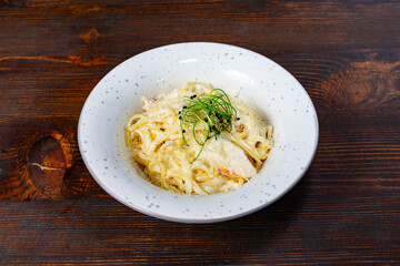 Creamy pasta dish served in a white bowl on a rustic wooden table Savory vegetable pie served with fresh garnishes