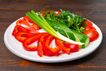 Freshly cut vegetables arranged on a white plate for a healthy meal Savory vegetable pie served with fresh garnishes