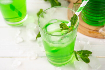 Middle Wastern limonana cocktail, mint liqueur lemonade, Lebanese mint lemonade drink, with crushed ice on white kitchen table background, copy space