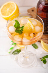 Infused tasty iced tea cocktails martini cocktail with lemon and mint, tasty refreshing non-alcohol mocktail on white wooden table background 
