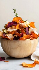 Vibrant selection of thinly sliced vegetable chips presented in a wooden bowl against a neutral background