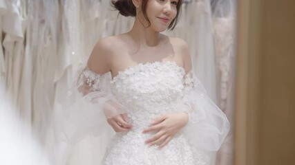 Close up beauty young adult happy woman asia people prepare lace clothes for tied knot wedding life event party get dressed up wear white dress try on fitting room modern luxury bridal store.