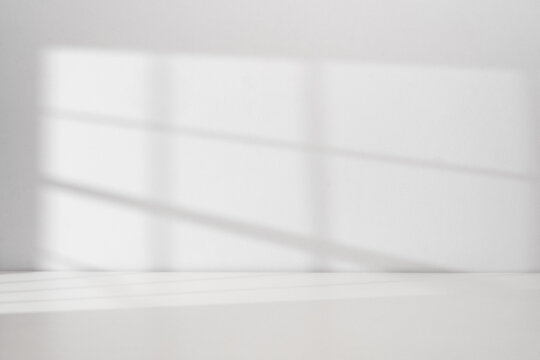 Sunlight coming through the window on the white wall background with copy space