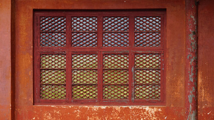 Antique wooden windows painted in reddish-brown color.