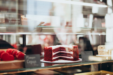 Red velvet cake on display in a pastry shop window.