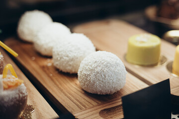Coconut cake in the shape of a ball in the window of a pastry shop, cafe.