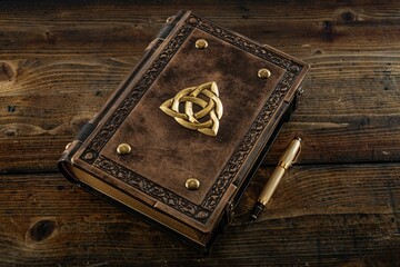 Brown leather book with the triquetra symbol 