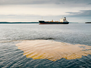 spilled stain of fuel oil on the surface of the water