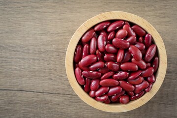 Red kidney beans in wooden bowl on wooden background	