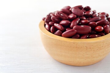 Red kidney beans in wooden bowl on white background