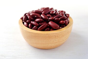 Red kidney beans in wooden bowl on white background