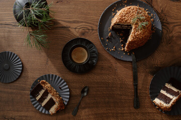 Dark chocolate handmade cake served on black plate on oak table
