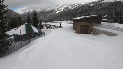 Picturesque Winter View Of Snow-covered Ski Slope With Wooden Fence And Alpine Building
