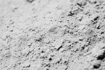 Close-up of volcanic ash texture, soft gray powder with tiny porous rock fragments.
