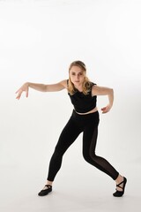 Young dancer performs contemporary dance moves in a minimalist studio setting with bright background