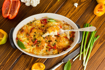 cauliflower baked with sweet pepper and vegetables under cheese
