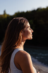 Portrait of young  woman with long hair enjoying sun with closed eyes