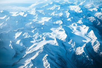 Fototapeta premium Aerial perspective of glacier textures, with sharp icy blue contrasts against deep white snow-covered mountains.