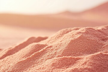 A close-up of the sand pile, highlighting its texture and color against an out-of-focus desert background.
