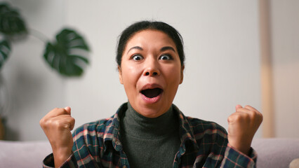 Happy excited Hispanic woman celebrates sports team victory