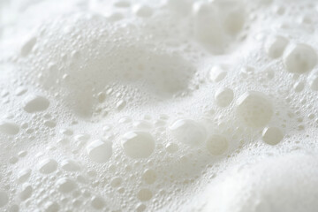 Fototapeta premium Macro shot of white foam on ocean waves, soft and airy bubbles creating texture.