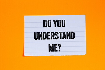 Do you understand me message written on ripped torn white paper piece on orange background....
