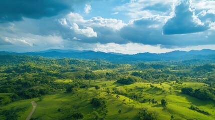Obraz premium Serene Aerial View of Lush Green Mountains and Rolling Hills Under a Cloudy Sky