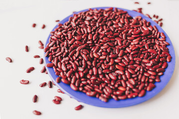 Vibrant display of kidney beans arranged beautifully on a blue plate, showcasing their rich color and texture in natural light