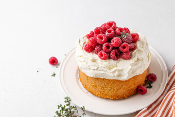 Homemade classic victoria vanilla sponge cake or biscuit or pie decorated with whipped cream and fresh strawberries on top on a light background. Summer dessert. Copy space. Selective focus.