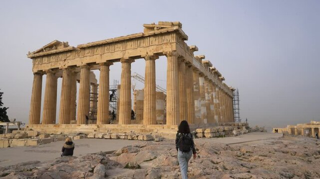 Woman looking at Parthenon ancient temple dedicated to goddess Athena in Athens, Greece