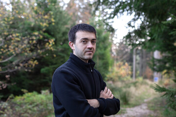 porttait of a young man walking alone in the autumn forest in Black Forest Germany. nature and person