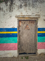 Old wooden door on a disheveled plaster wall