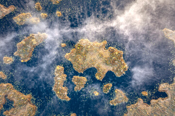 Drone panorama on tiny isles in lake in colorful sunrise colors. Top down view on swamp with isle. Sustainable ecosystem of wetlands.