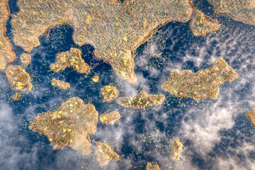 Drone panorama on tiny isles in lake in colorful sunrise colors. Top down view on swamp with isle. Sustainable ecosystem of wetlands.