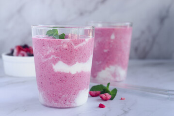 a glass of mixed berry yogurt smoothie on marble table background. 