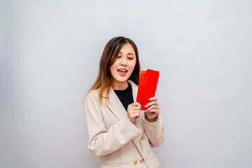 Woman Holding a Red Envelope with Money,Lunar New Year Red Packet with Cash,Bonus and Salary Concept – Financial Success and Wealth