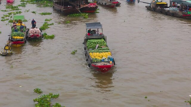 Aerial view of Cai Rang floating market, Can Tho, Vietnam. Tourists, people buy and sell food, vegetable, fruits on boat, ship at river market in Tet Holiday.
