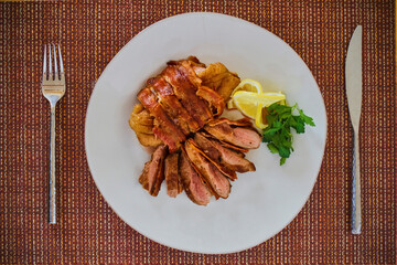 bacon wrapped duck breast sliced on a plate