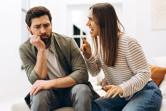 Young woman arguing with her sad husband at home