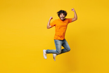 Full body young happy fun overjoyed cheerful cool Indian man he wear orange t-shirt casual clothes...