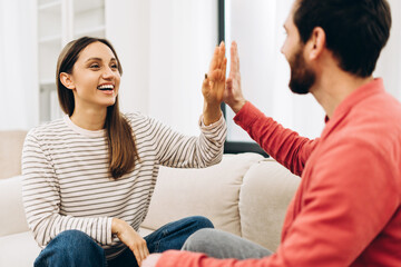 Happy couple giving high five celebrating success at home