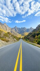 Naklejka premium A picturesque mountain road winds its way through a stunning autumn landscape, illuminated by the warm glow of the afternoon sun