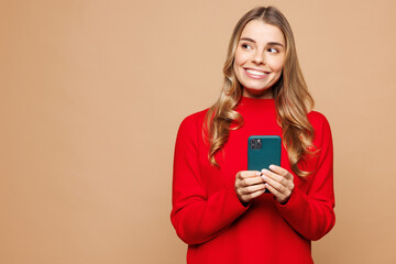Young fun Caucasian woman she wear red casual clothes hold in hand use mobile cell phone look aside...