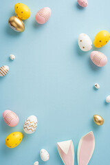 Decorative vertical Easter eggs in pastel shades and bunny ears arranged on a blue background