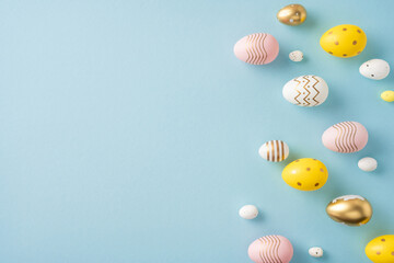 Colorful and decorative Easter eggs with patterns arranged on a pastel blue backdrop