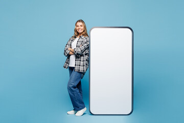 Full body side view young smiling woman she wears checkered grey shirt casual clothes stand near...