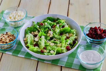 mixed green salad topped with dried fruit and nuts