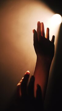 Silhouette of a hand reaching towards light